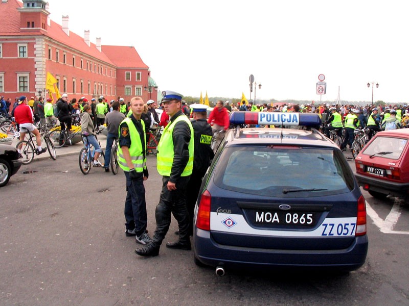 Policyjny radiowóz a w tle rowerzyści