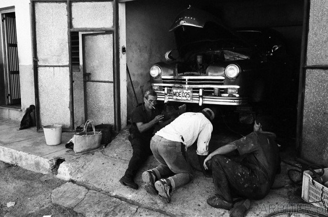 Panowie remontujący auto Plymouth. Na Kubie nie istnieje rynek części zamiennych. ...